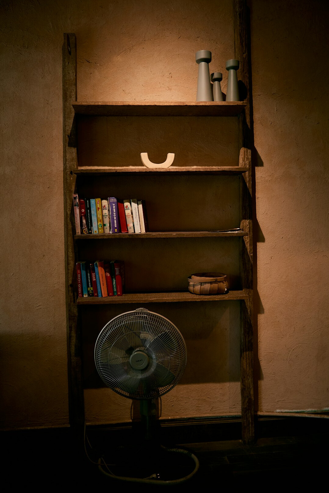 Stacked old books on a wooden shelf