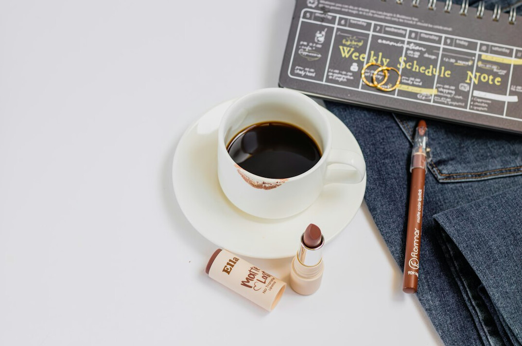Close-up of an analog notebook with a pen and a cup of coffee
